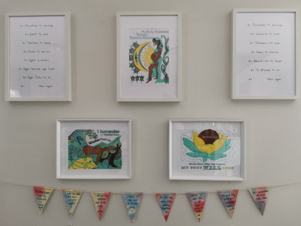 Birth preparation art and pennant affirmations hung on a wall